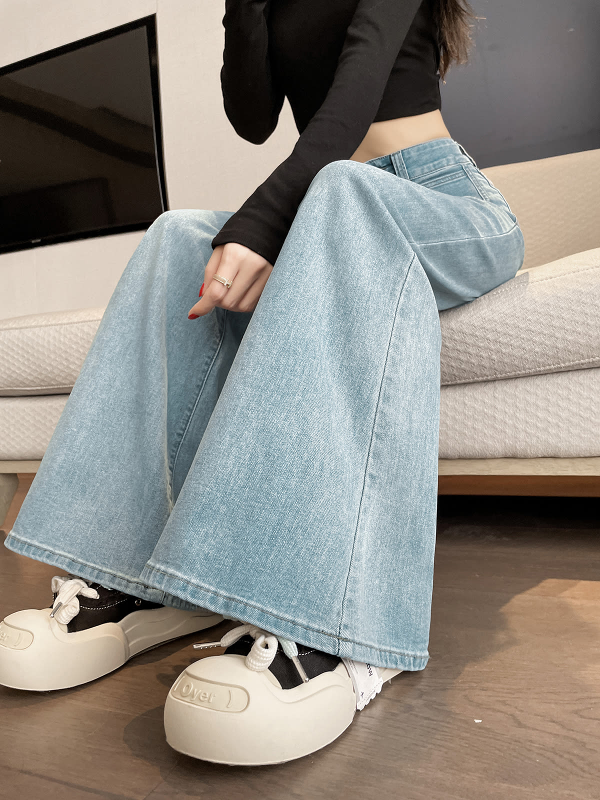YEEYEEWang wide-leg jeans in light wash blue, Asian-fit cut, model sitting pose highlighting wide hem drape.