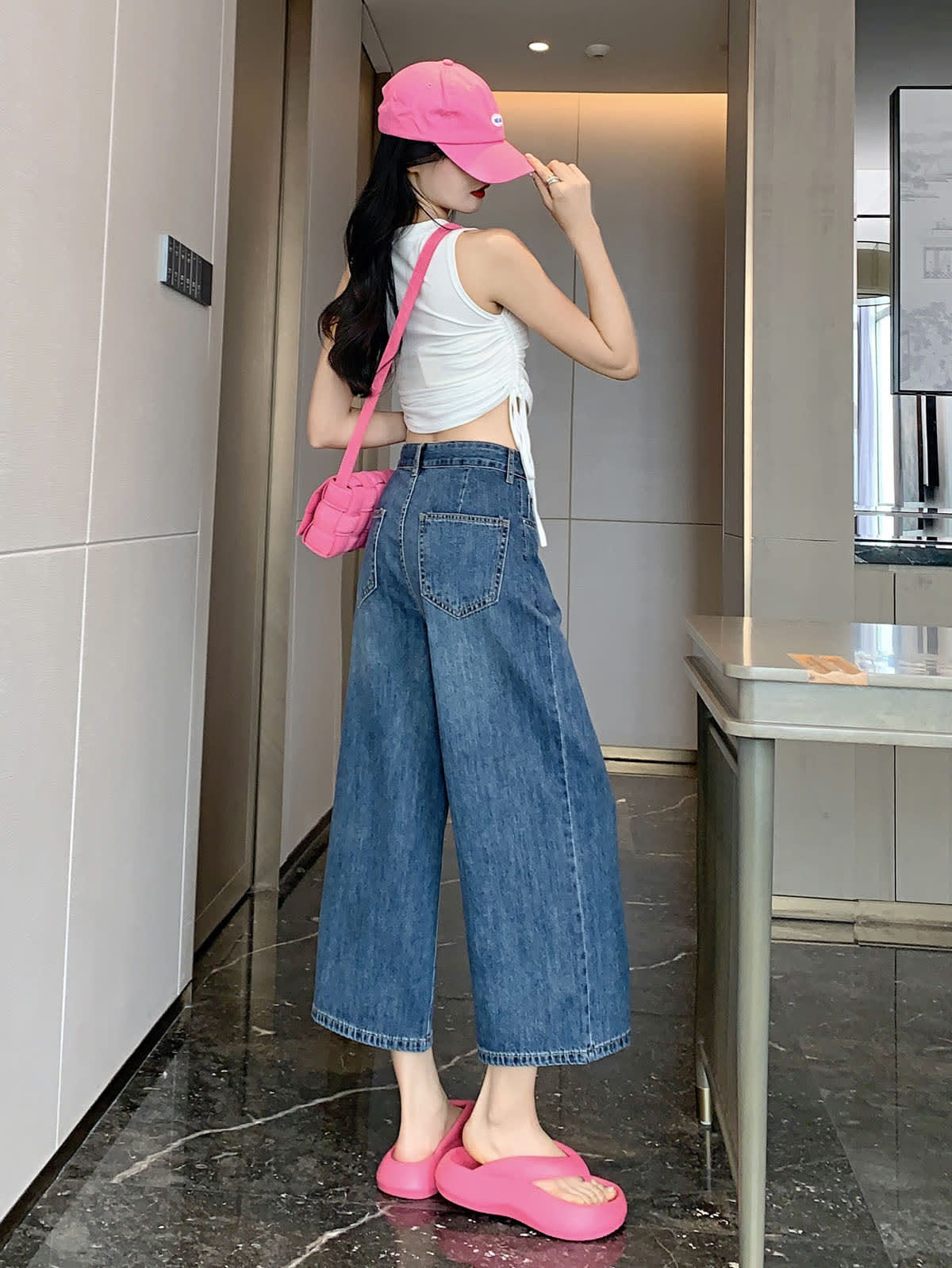 YEEYEEWang Wide-Leg Jeans in Vintage Blue, Asian-fit cut, full-body back view standing, back patch pockets visible, pink cap and crossbody bag.