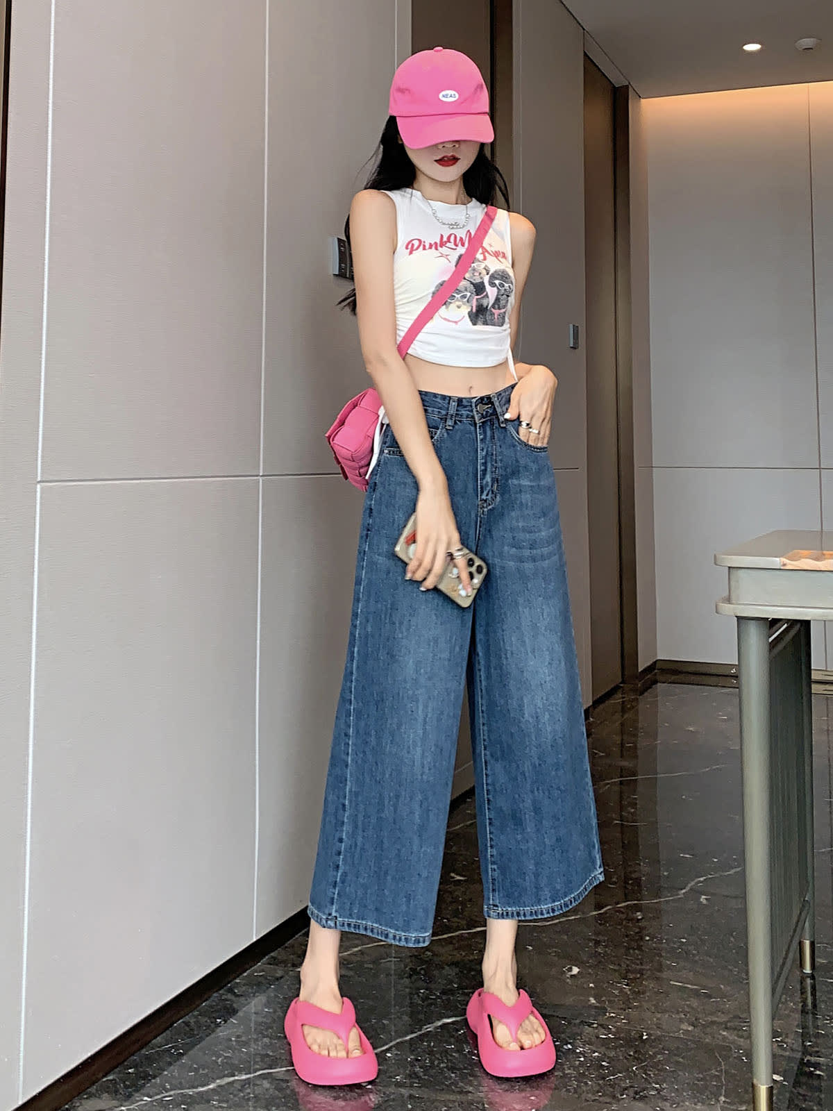 YEEYEEWang Wide-Leg Jeans in Vintage Blue, Asian-fit cut, full-body front standing pose, one hand in front pocket, other hand holding phone, pink cap and crossbody bag.
