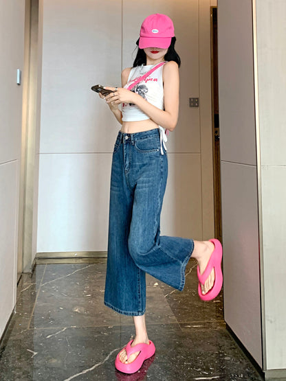 YEEYEEWang Wide-Leg Jeans in Vintage Blue, Asian-fit cut, full-body leg-kick pose checking phone, showing the Cropped (8) hem, pink cap and sandals.
