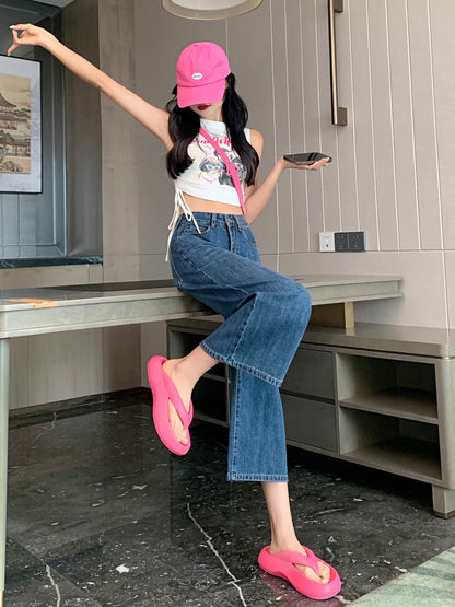 YEEYEEWang Wide-Leg Jeans in Vintage Blue, Asian-fit cut, full-body side seated pose on table edge with one arm raised and leg lifted, holding phone, pink cap.