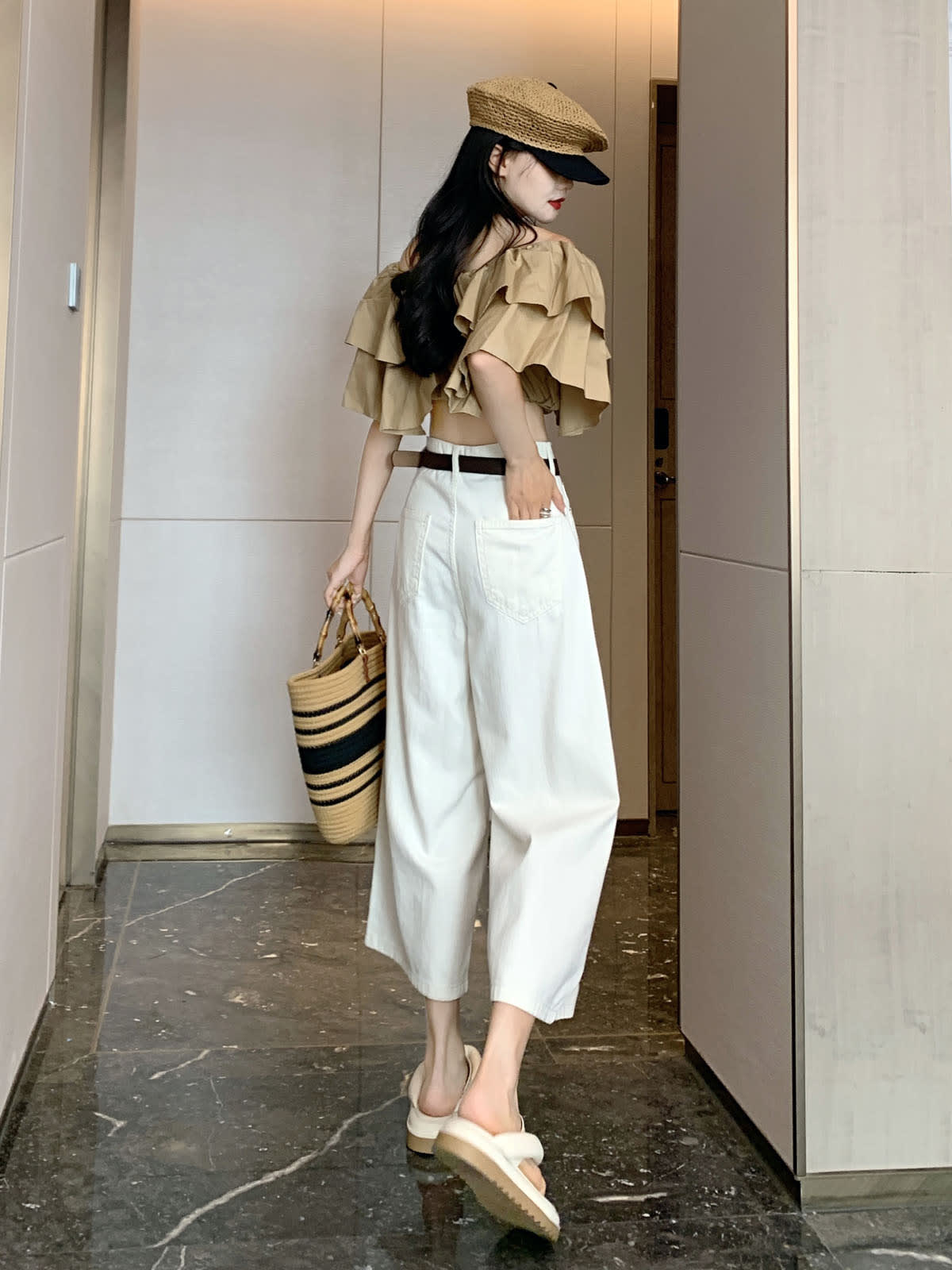 YEEYEEWang Wide-Leg Jeans in Ivory, Asian-fit cut, full-body back-side walking view holding straw tote, back patch pockets and black belt visible.