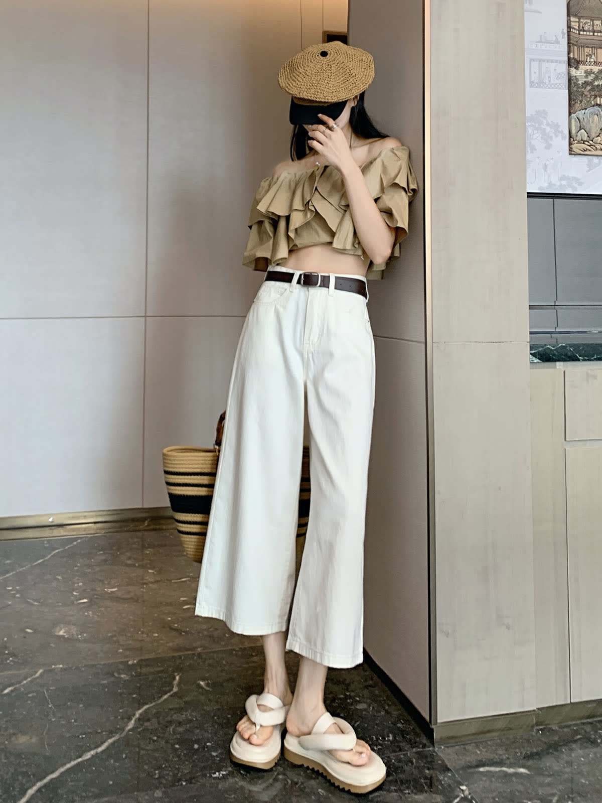 YEEYEEWang Wide-Leg Jeans in Ivory, Asian-fit cut, full-body side pose leaning against wall, off-shoulder ruffle top and straw cap.