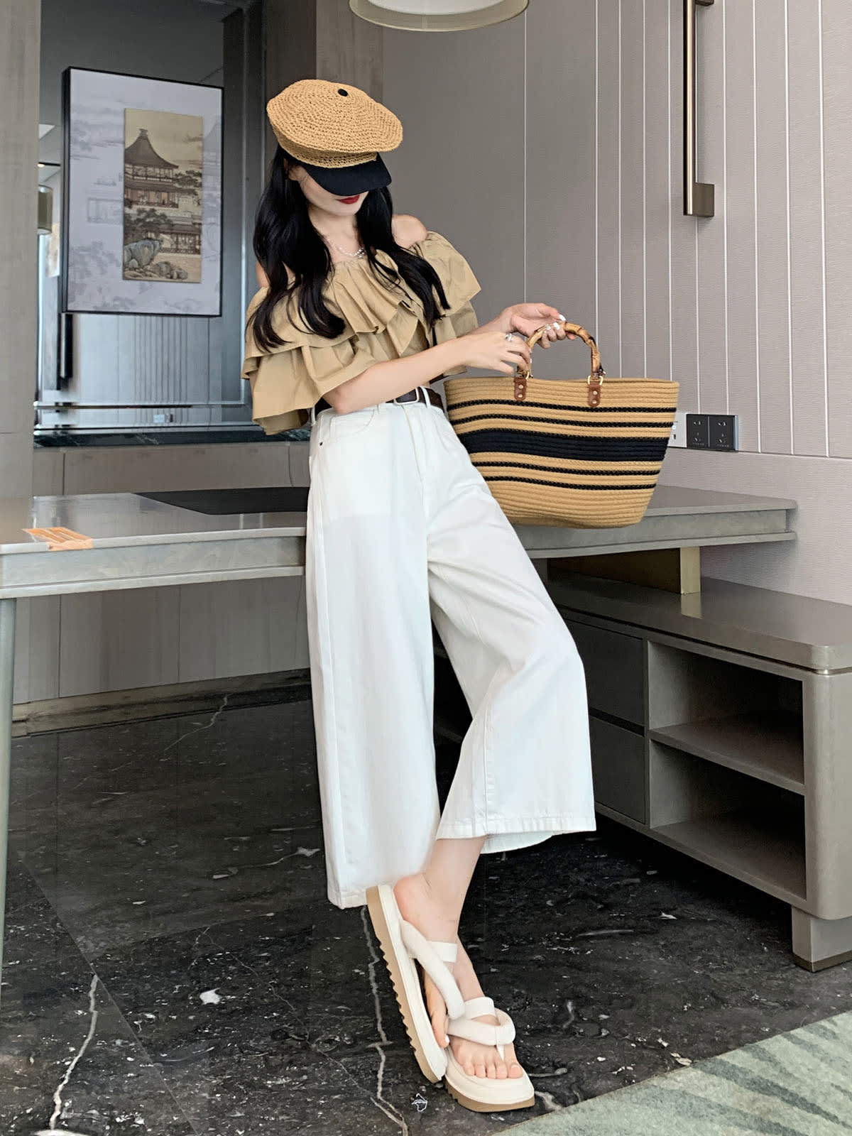 YEEYEEWang Wide-Leg Jeans in Ivory, Asian-fit cut, full-body side pose with one leg stepped forward, holding striped straw tote, woven cap.