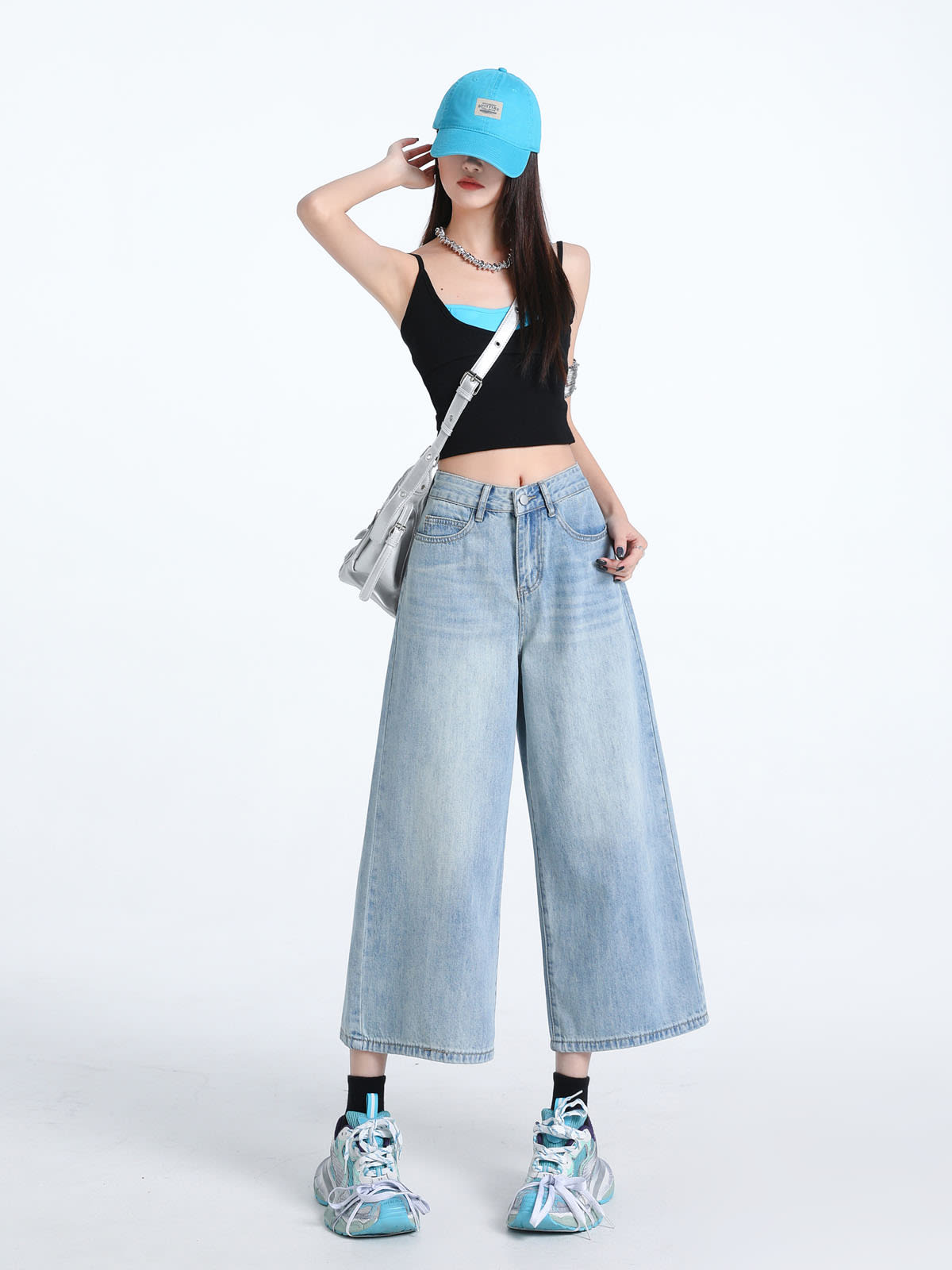 YEEYEEWang Wide-Leg Jeans in Light Blue, Asian-fit cut, full-body front pose with one hand touching cap brim, silver crossbody bag at hip.