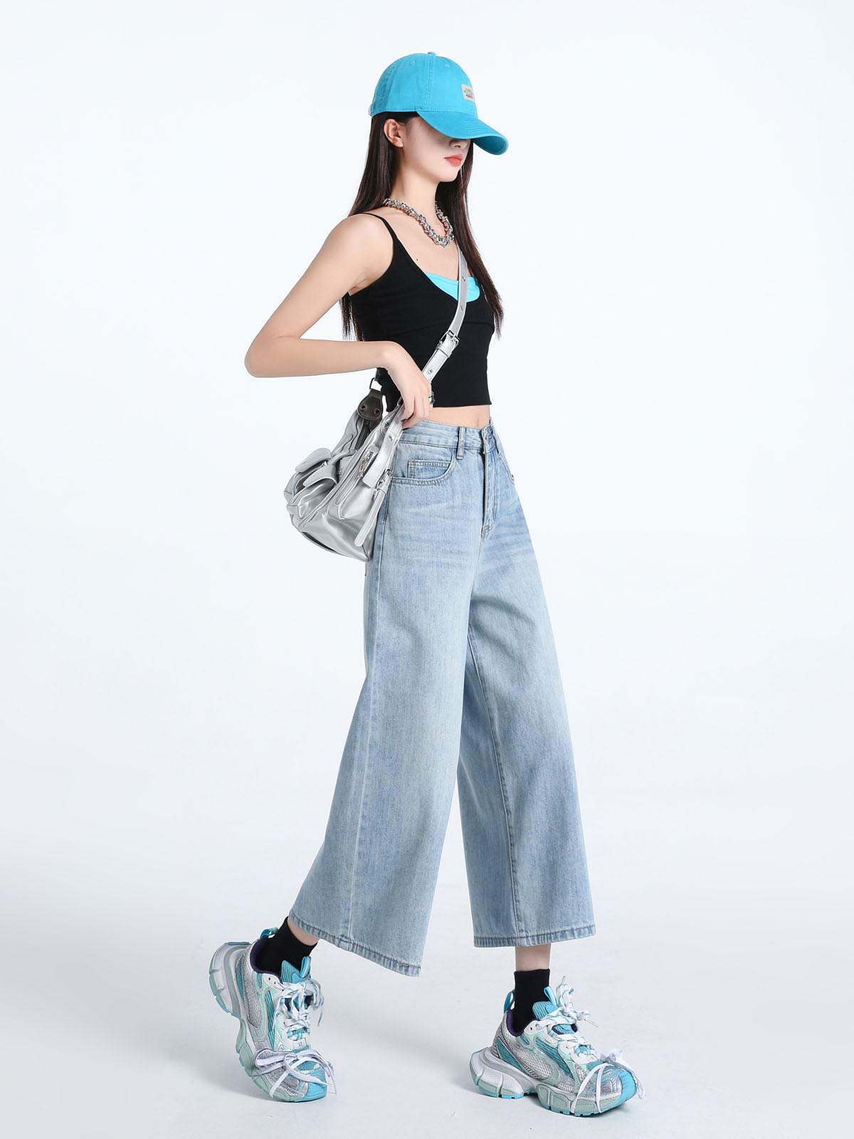 YEEYEEWang Wide-Leg Jeans in Light Blue, Asian-fit cut, full-body side walking pose holding silver bag strap, blue cap and chunky sneakers.