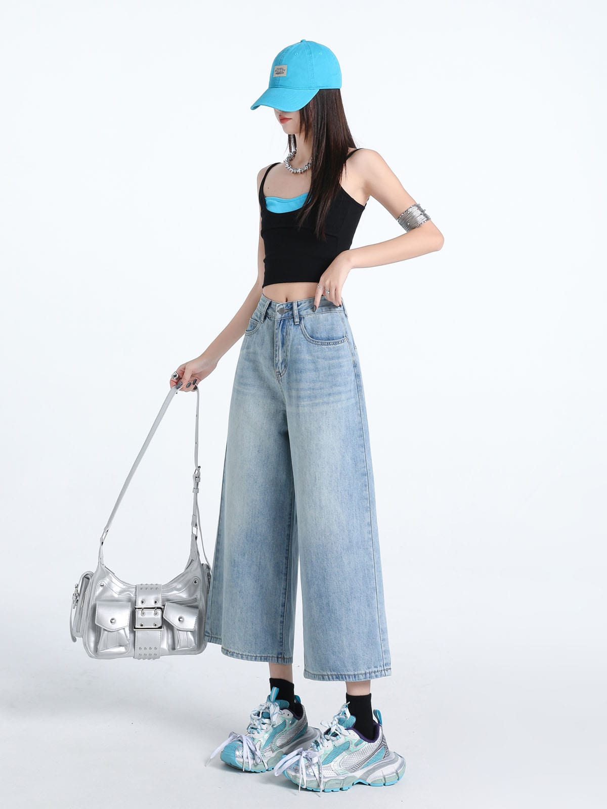 YEEYEEWang Wide-Leg Jeans in Light Blue, Asian-fit cut, full-body side pose holding silver bag down by its strap, one hand resting on waistband.