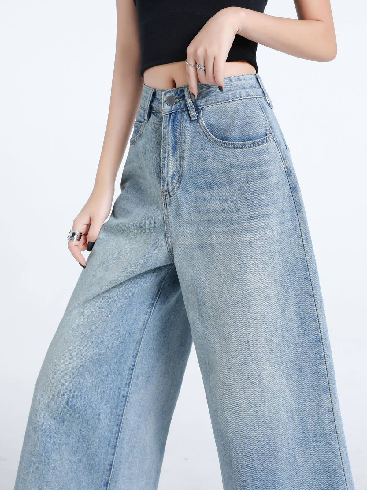 YEEYEEWang Wide-Leg Jeans in Light Blue, Asian-fit cut, waist-down front close view of high-rise waistband and button fly, one hand at the waistband.