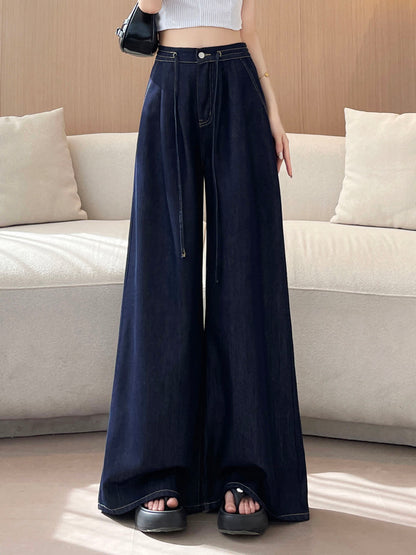 YEEYEEWang wide-leg jeans in Denim Blue, Asian-fit cut, waist-down front view of flowing wide legs with drawstring waist and black shoulder bag, variant thumbnail.