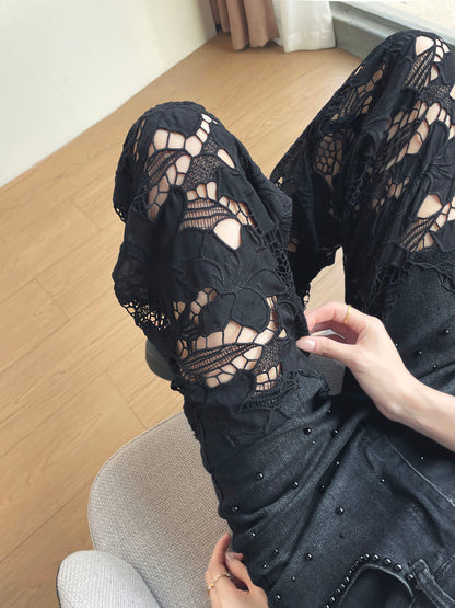 YEEYEEWang Wide-Leg Jeans in Solid Black, Asian-fit cut, waist-down view seated with knee bent up, hand touching the floral lace cutout panel on the leg.