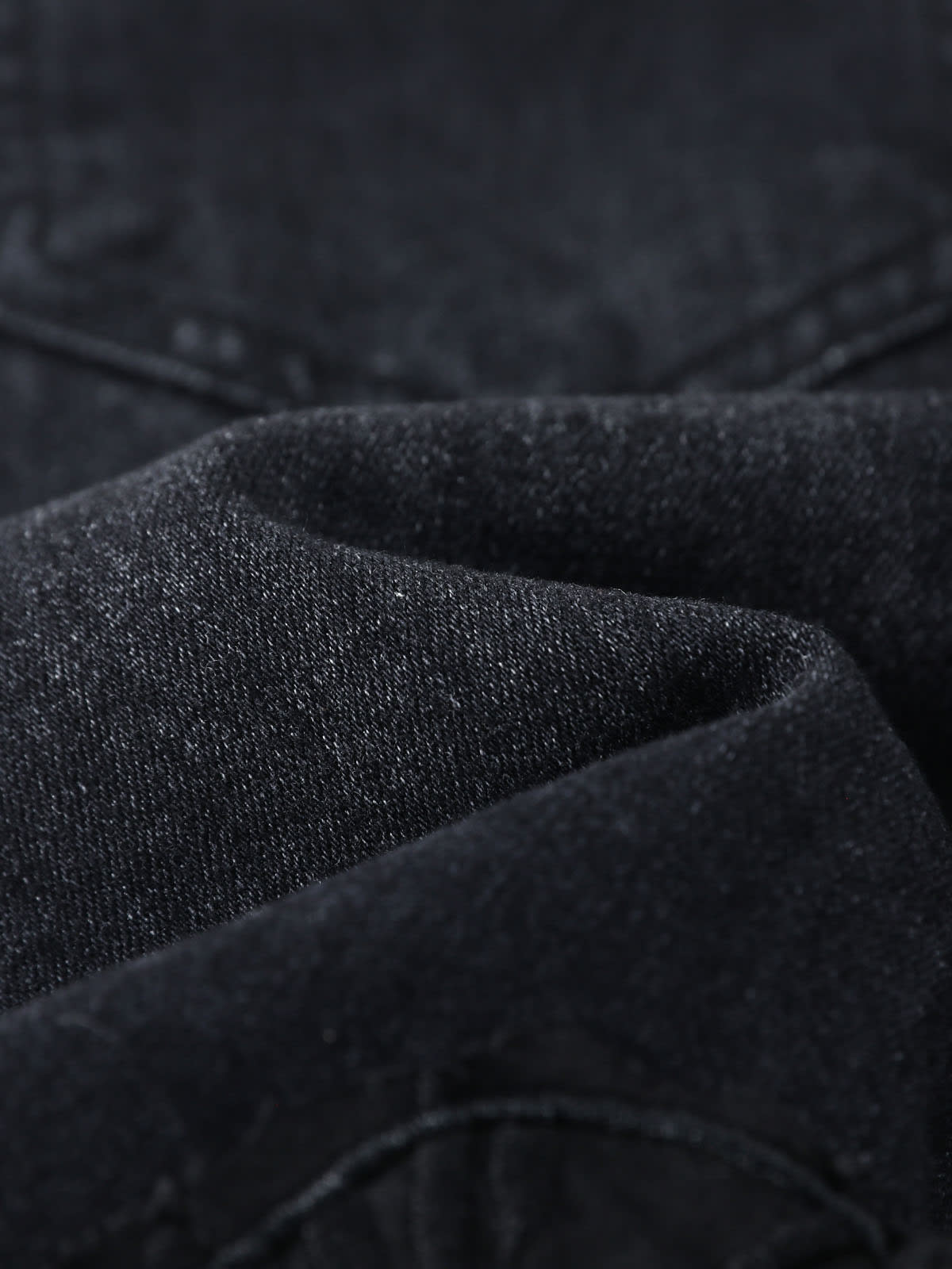 YEEYEEWang Wide-Leg Jeans in Solid Black, Asian-fit cut, close-up of softly folded dark denim fabric showing fine twill texture and subtle sheen.