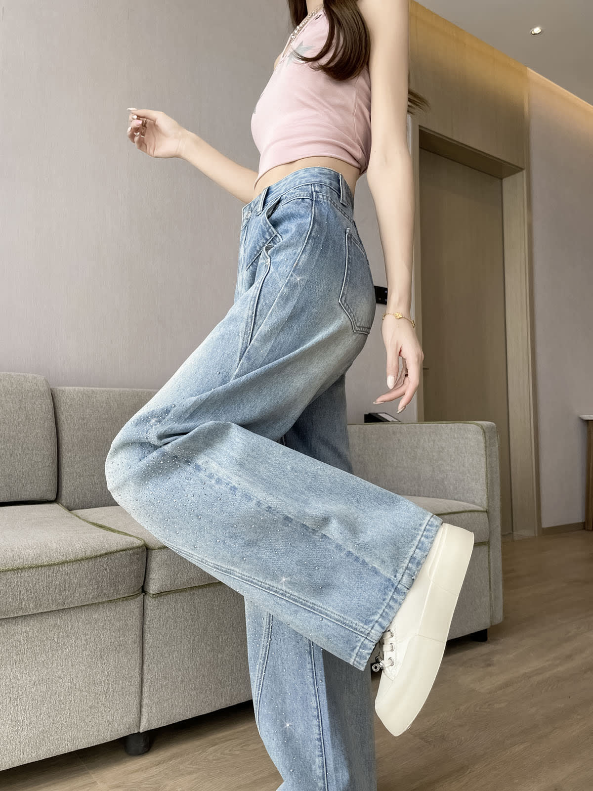 YEEYEEWang Wide-Leg Jeans in Light Blue, Asian-fit cut, waist-down leg-kick pose showing side seam stitching, back patch pocket and wide flared hem in motion.