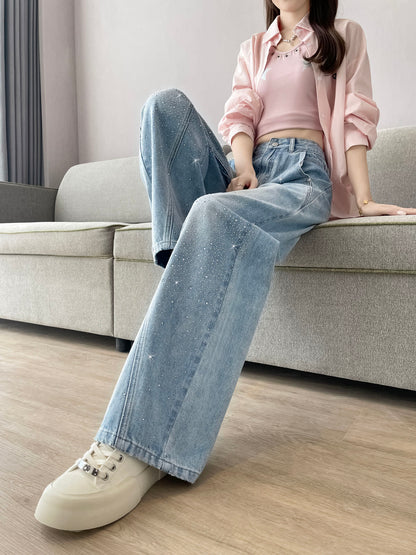 YEEYEEWang Wide-Leg Jeans in Light Blue, Asian-fit cut, waist-down seated pose on sofa with legs crossed and extended, pink shirt over tank, crystal-embellished denim.