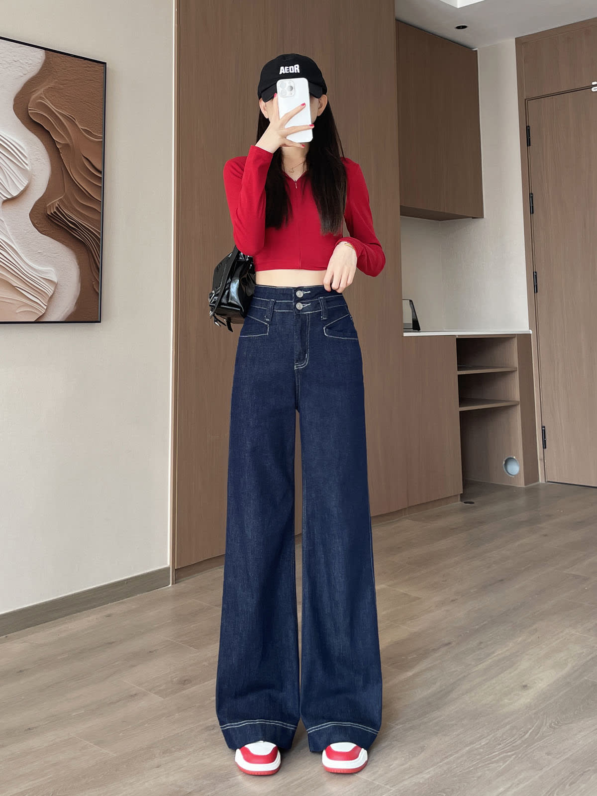 YEEYEEWang Wide-Leg jeans in Denim Blue, Asian-fit cut, full-body front pose holding phone at face, black cap and black bag.