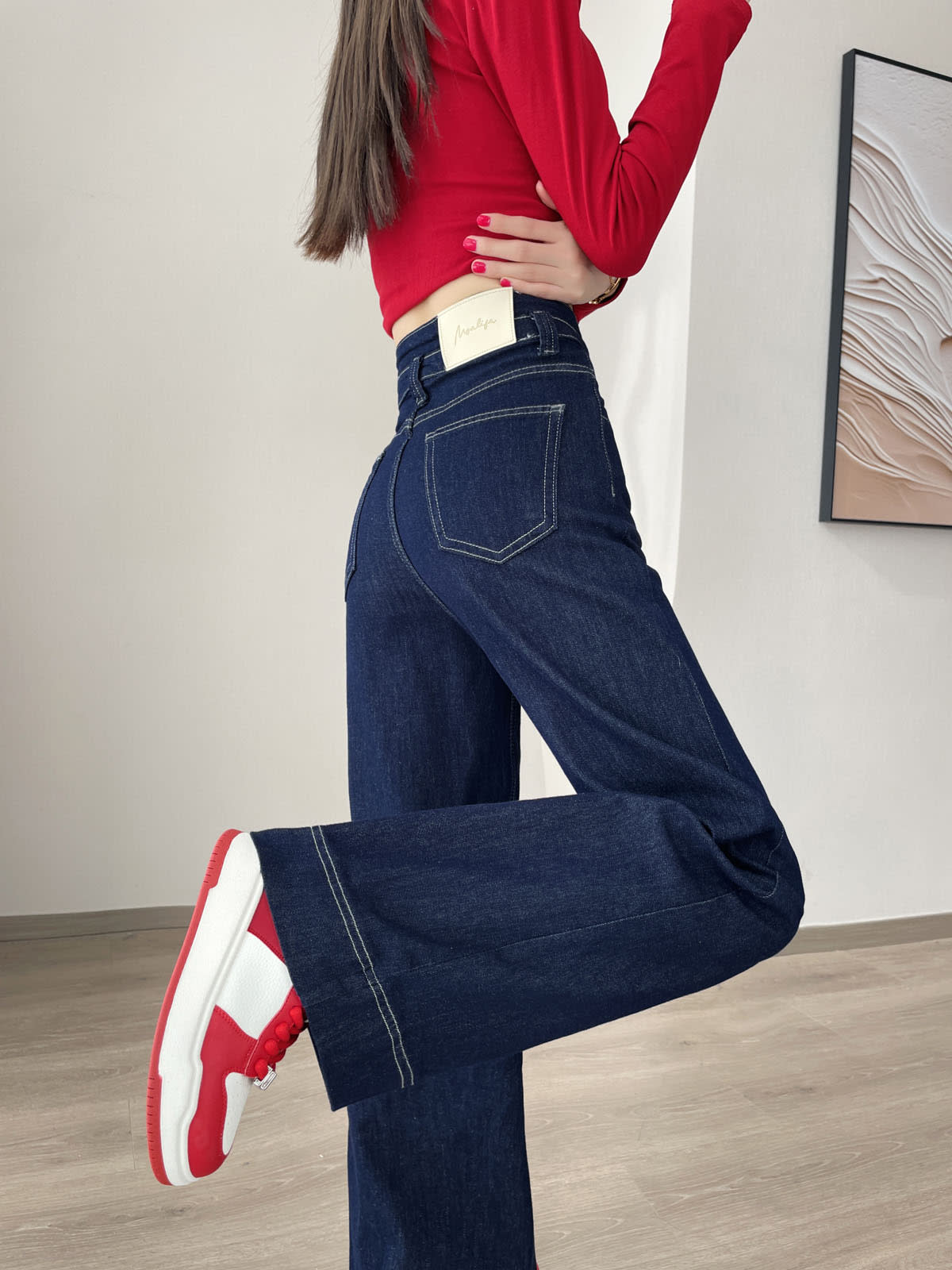 YEEYEEWang Wide-Leg jeans in Denim Blue, Asian-fit cut, leg-kick pose showing back patch pocket and contrast stitching, red sneakers.
