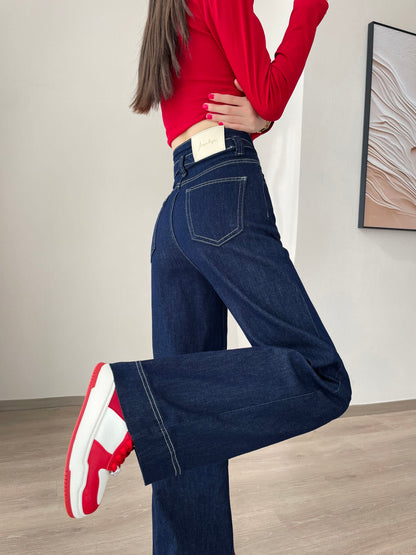 YEEYEEWang Wide-Leg jeans in Denim Blue, Asian-fit cut, leg-kick pose showing back patch pocket and contrast stitching, red sneakers.