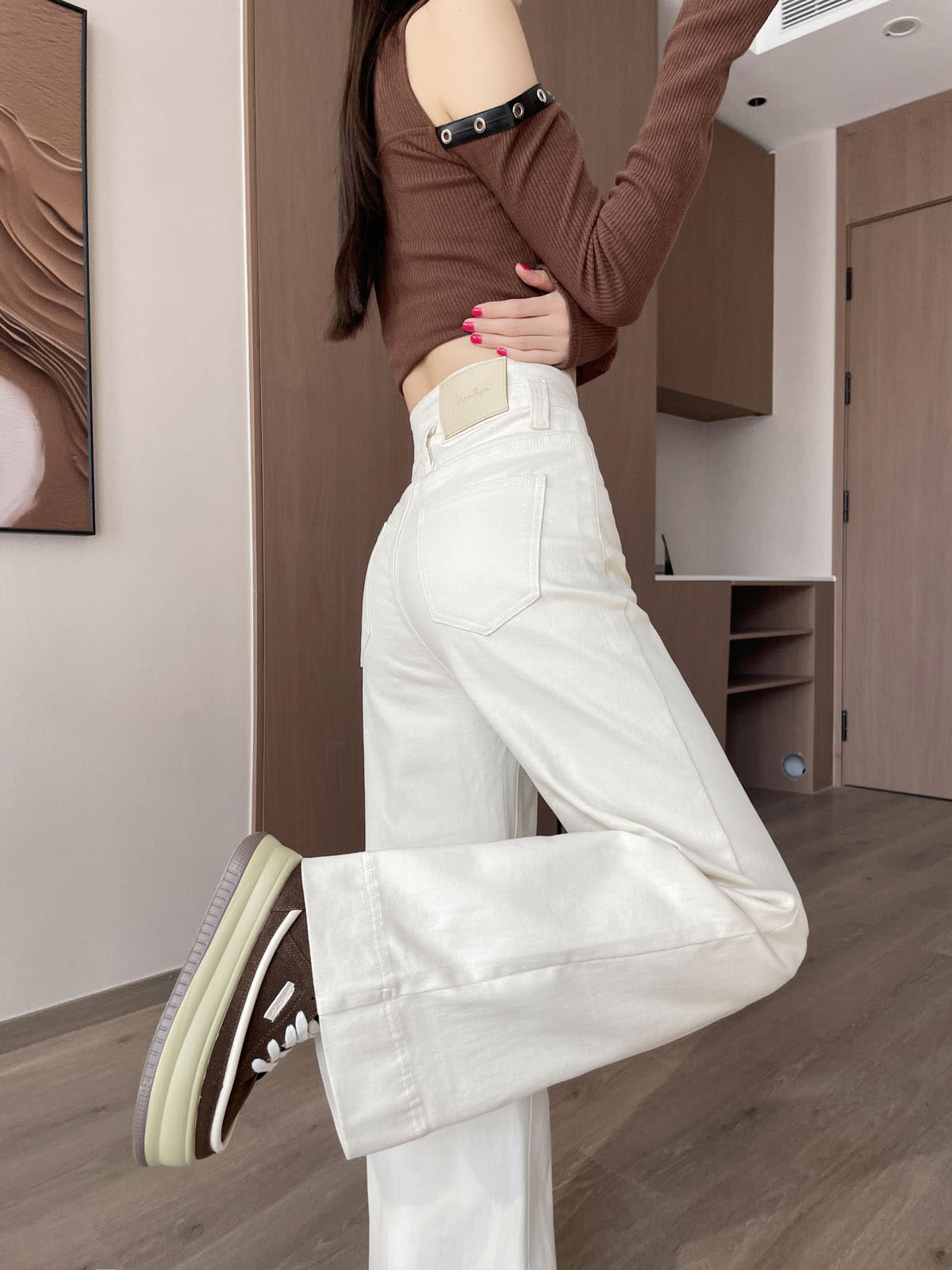 YEEYEEWang Wide-Leg jeans in Ivory, Asian-fit cut, leg-kick pose showing back patch pocket and leather patch, brown sneakers.