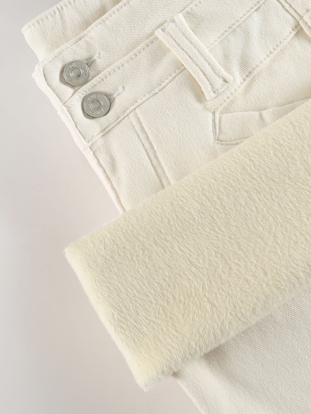 YEEYEEWang Wide-Leg Jeans in Ivory, Fleece-Lined, Asian-fit cut, close-up of silver-tone double buttons on waistband beside fluffy fleece lining.