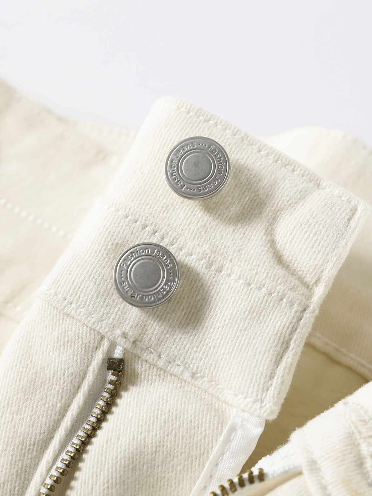 YEEYEEWang Wide-Leg Jeans in Ivory, Fleece-Lined, Asian-fit cut, close-up of engraved silver-tone buttons and antique bronze zipper fly detail.