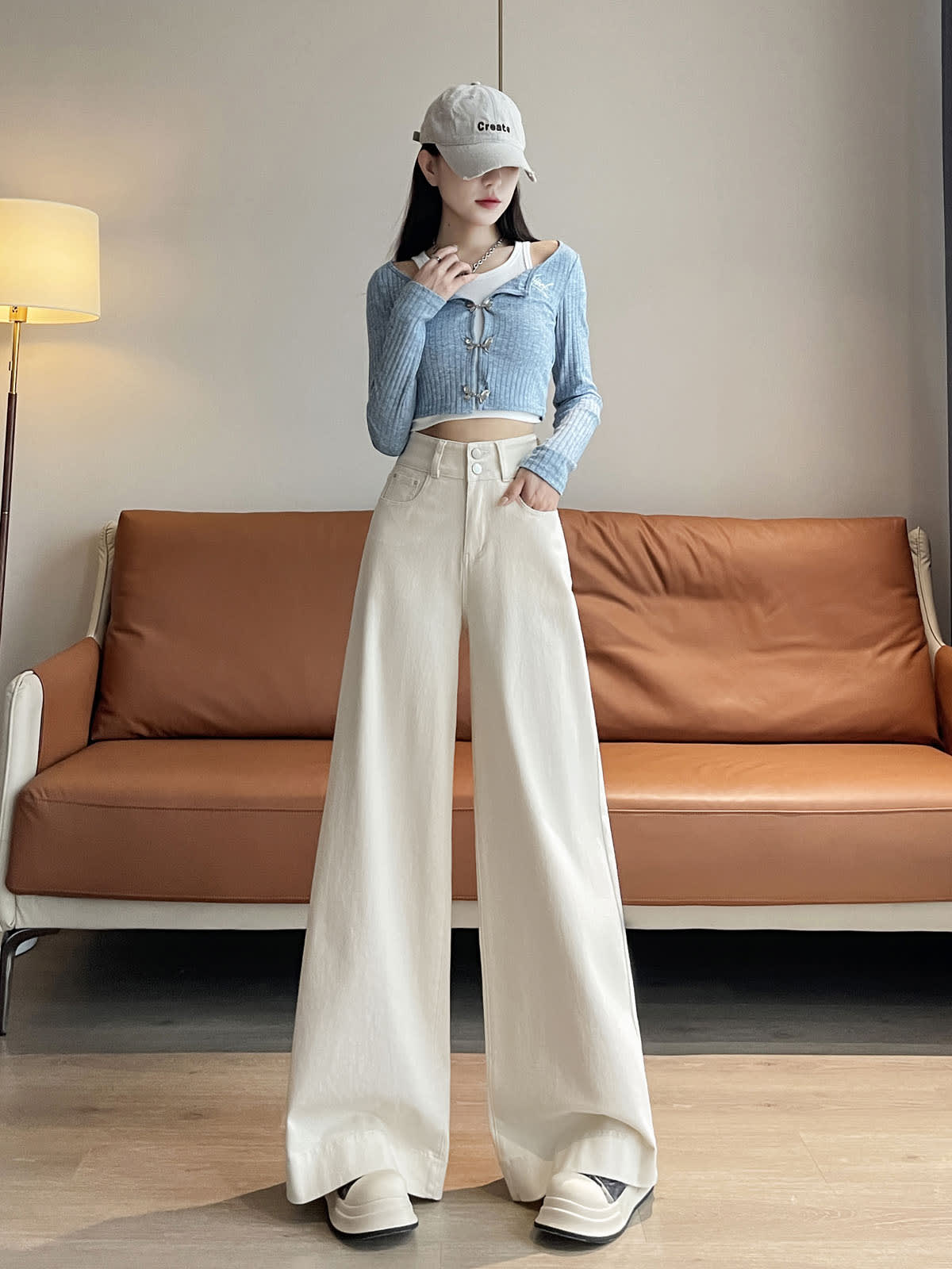 YEEYEEWang wide-leg jeans in Ivory, Asian-fit cut, full-body standing front pose in gray cap and blue cardigan, hand in pocket.