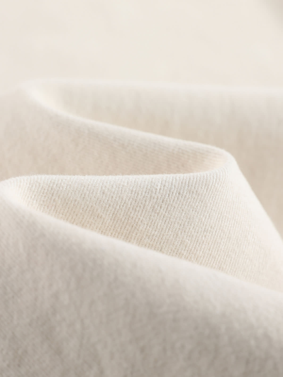 YEEYEEWang wide-leg jeans in Ivory, Asian-fit cut, close-up of soft cream denim texture with gentle folds and fine twill weave.