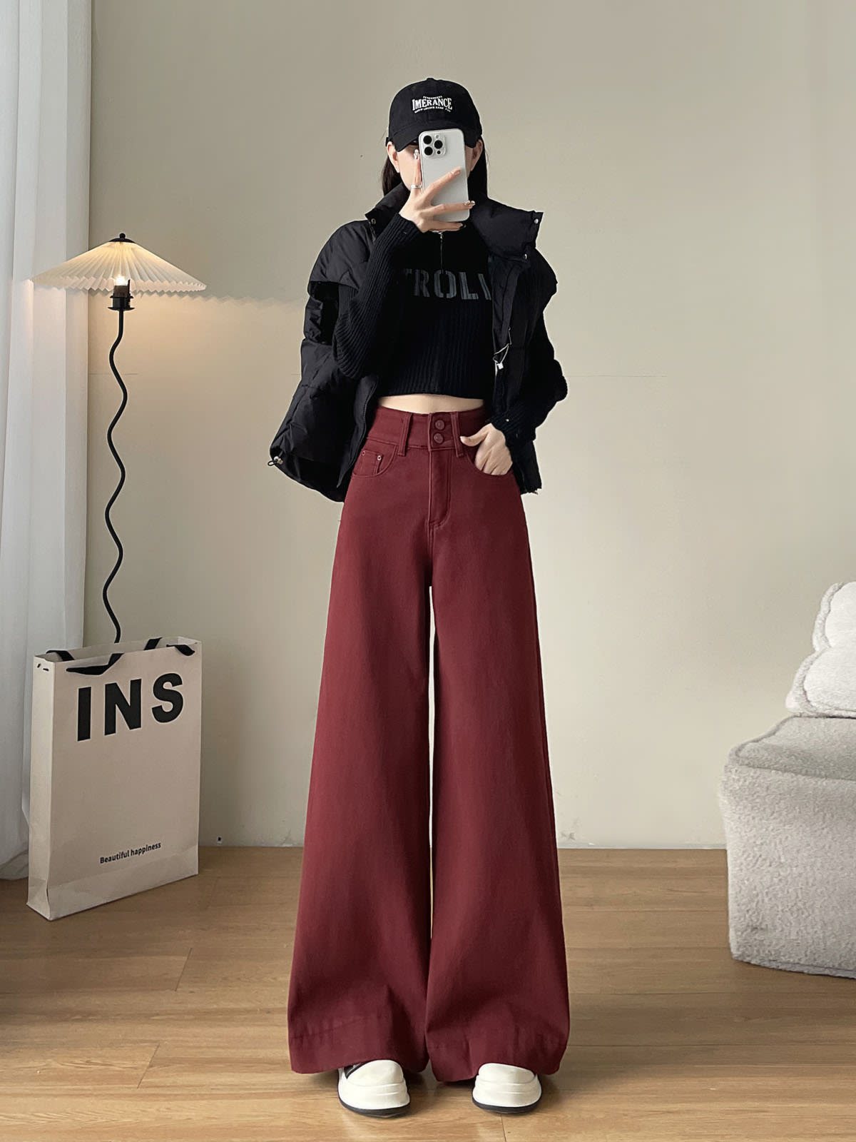 YEEYEEWang wide-leg jeans in Dark Cherry, Asian-fit cut, full-body front pose holding phone at face, black vest and cap with knit top.