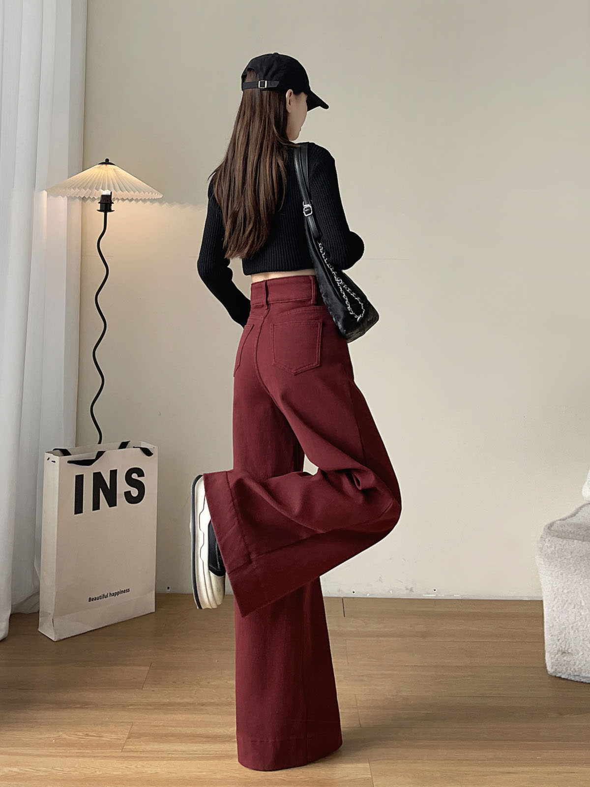 YEEYEEWang wide-leg jeans in Dark Cherry, Asian-fit cut, full-body back leg-kick pose in black cap, black chain bag over shoulder.