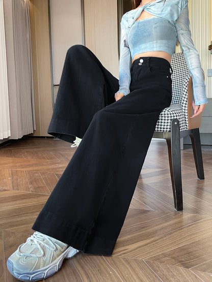 YEEYEEWang wide-leg jeans in Solid Black, Asian-fit cut, waist-down seated pose on chair with legs crossed, wide hem over white sneakers.