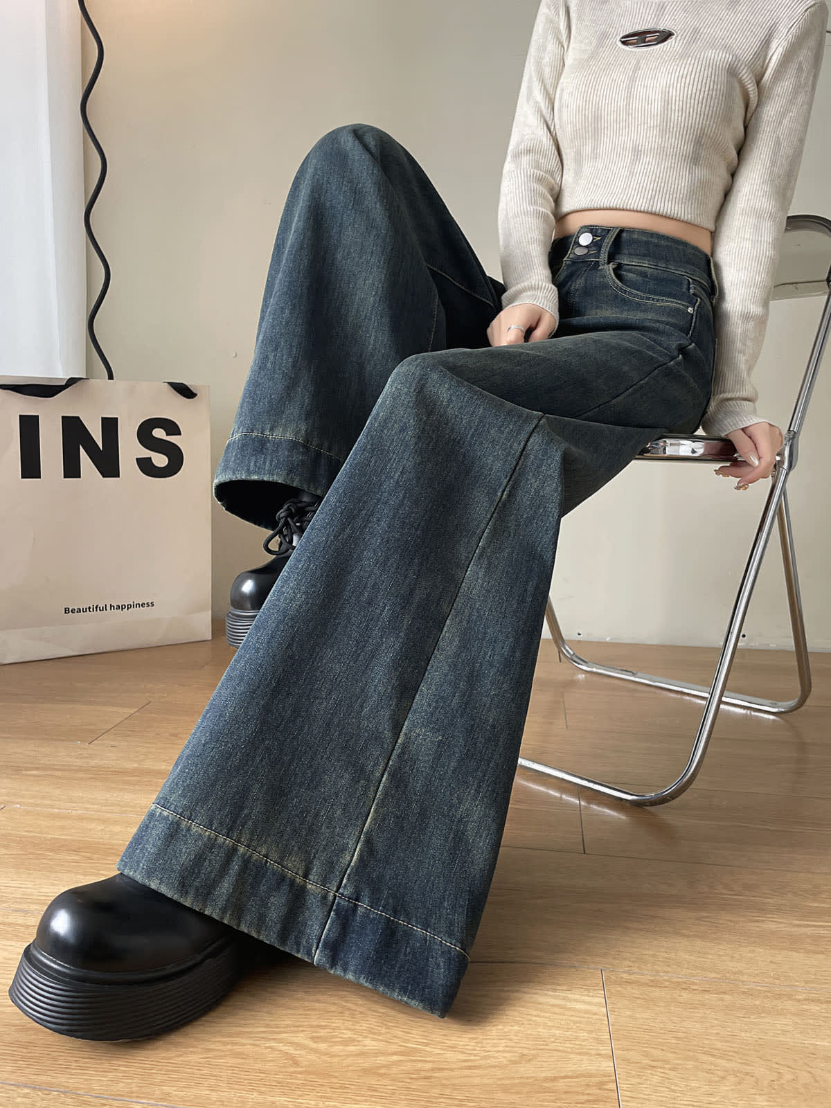 YEEYEEWang Fleece-Lined Wide-Leg Jeans in Mid-Wash Blue, waist-down seated pose on chair with legs crossed, floor-sweeping leg extended, Asian-fit cut.