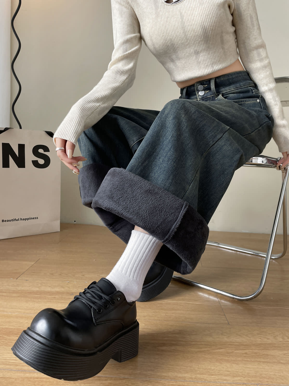 YEEYEEWang Fleece-Lined Wide-Leg Jeans in Mid-Wash Blue, waist-down squatting pose on chair, folded cuffs revealing plush fleece lining, Asian-fit cut.