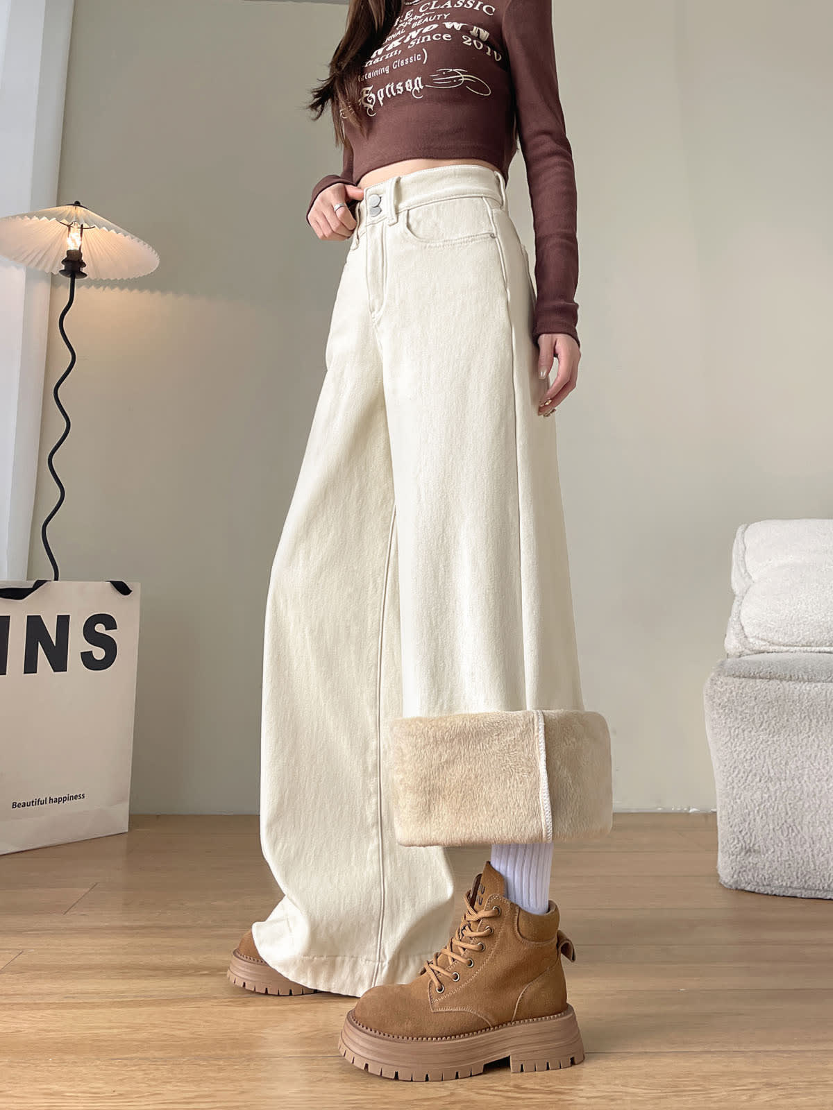 YEEYEEWang Fleece-Lined Wide-Leg Jeans in Ivory, full-body side standing view, one cuff folded up showing cream fleece lining, tan lace-up boots, Asian-fit cut.