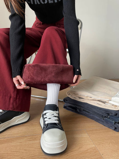 YEEYEEWang Fleece-Lined Wide-Leg Jeans in Dark Cherry, close-up of both hands holding folded cuff flat to show wine-red plush fleece lining, Asian-fit cut.