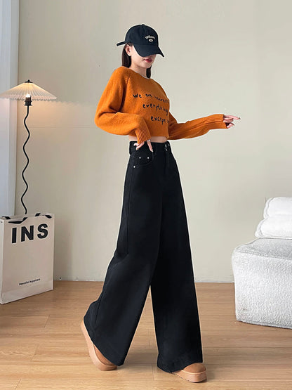 YEEYEEWang Fleece-Lined Wide-Leg Jeans in Solid Black, full-body front standing pose with one arm extended, orange letter-print sweater and black cap, Asian-fit cut.