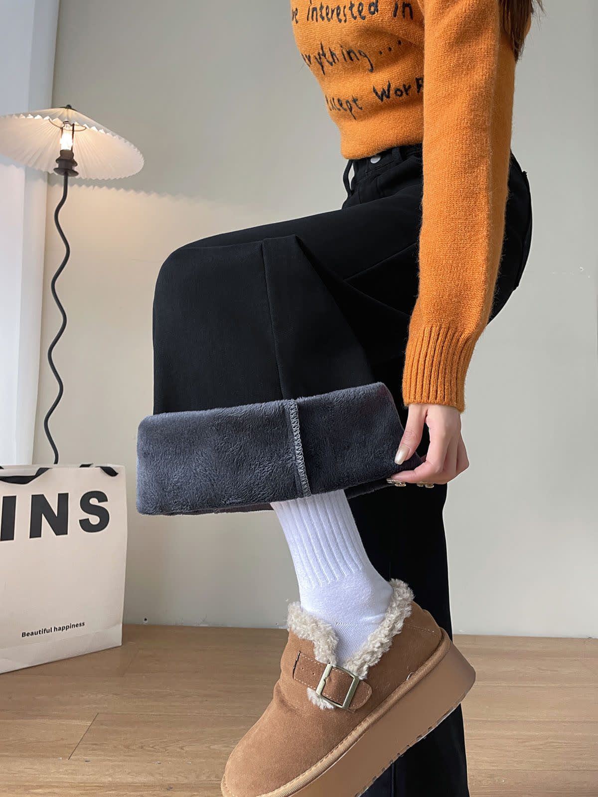 YEEYEEWang Fleece-Lined Wide-Leg Jeans in Solid Black, waist-down side view with leg lifted, folded cuff revealing grey plush fleece lining, Asian-fit cut.