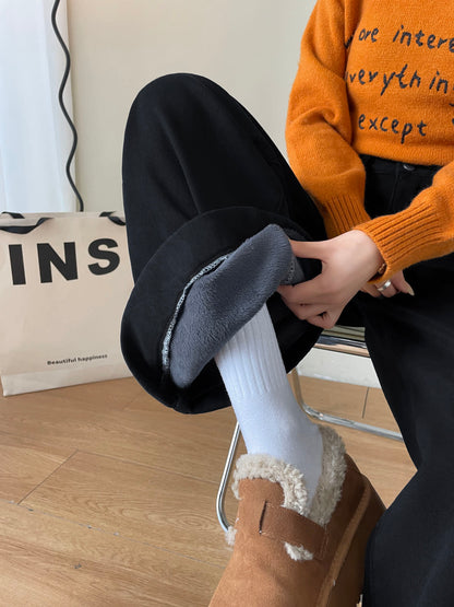 YEEYEEWang Fleece-Lined Wide-Leg Jeans in Solid Black, close-up of hand pulling open folded cuff to show grey plush fleece lining, Asian-fit cut.