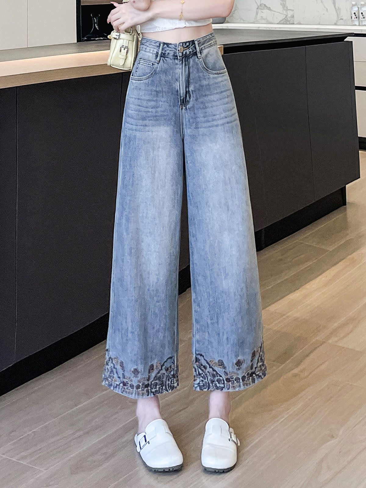 YEEYEEWang Wide-Leg Jeans in Light Blue, Asian-fit cut, waist-down standing pose showing high waist and paisley-embroidered hems with white buckle mules, variant thumbnail.