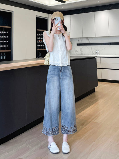 YEEYEEWang Wide-Leg Jeans in Light Blue, Asian-fit cut, full-body standing pose holding phone at face, white eyelet top and cream shoulder bag, embroidered hems in bright kitchen.