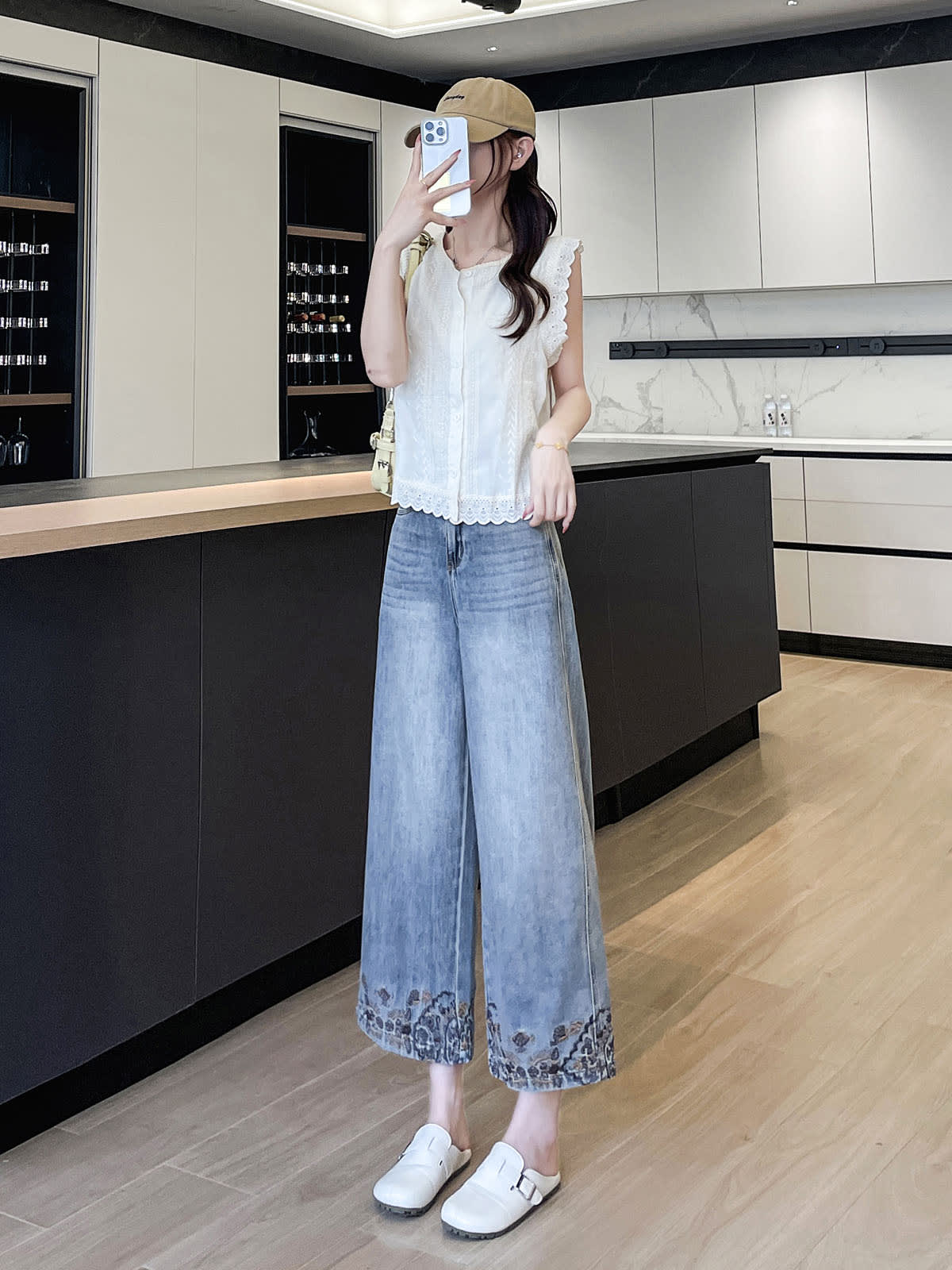 YEEYEEWang Wide-Leg Jeans in Light Blue, Asian-fit cut, full-body standing pose holding phone at face with one hand, beige cap and cream shoulder bag, relaxed straight-leg drape.