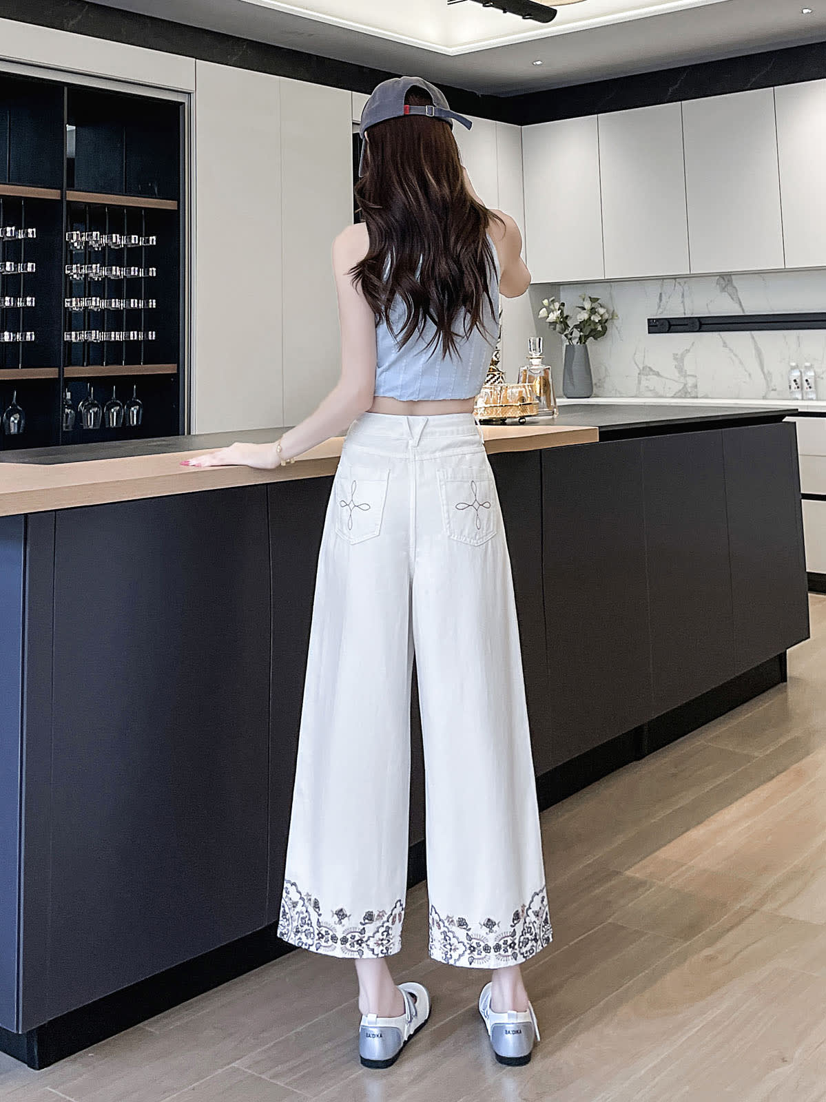 YEEYEEWang Wide-Leg Jeans in Ivory, Asian-fit cut, full-body back view standing, back patch pockets with floral stitching and embroidered hems.