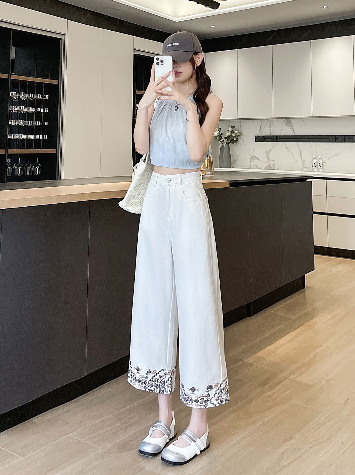 YEEYEEWang Wide-Leg Jeans in Ivory, Asian-fit cut, full-body front standing pose holding phone at face, heart pendant necklace, floral embroidered hems.