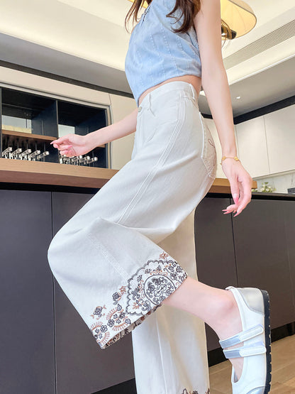 YEEYEEWang Wide-Leg Jeans in Ivory, Asian-fit cut, waist-down side view in leg-kick pose, fluid drape and floral embroidered hem in motion.