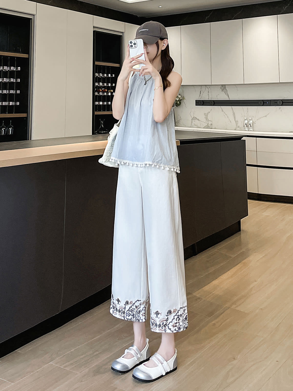 YEEYEEWang Wide-Leg Jeans in Ivory, Asian-fit cut, full-body front standing pose holding phone with both hands at face, woven bag on shoulder.