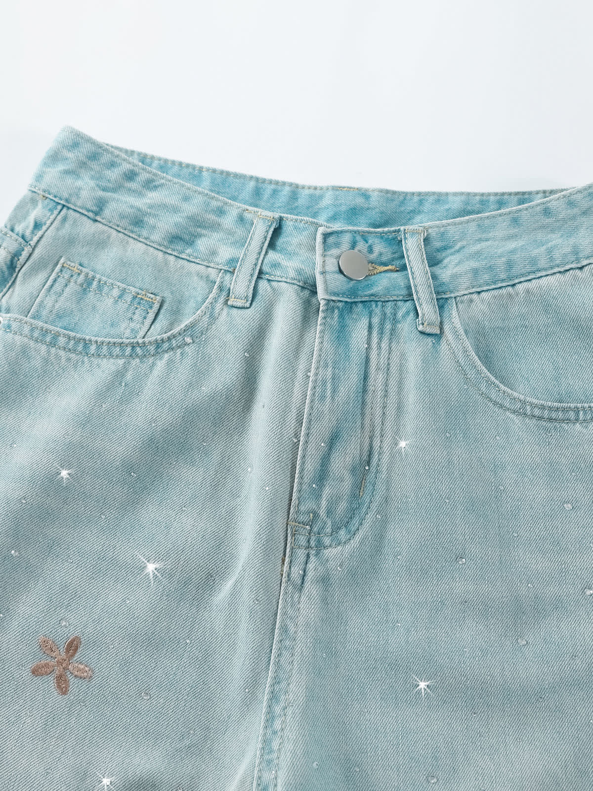 YEEYEEWang Wide-Leg Jeans in Light Blue, Asian-fit cut, close-up of waistband with belt loops, silver-tone button and small floral embroidery on white background.