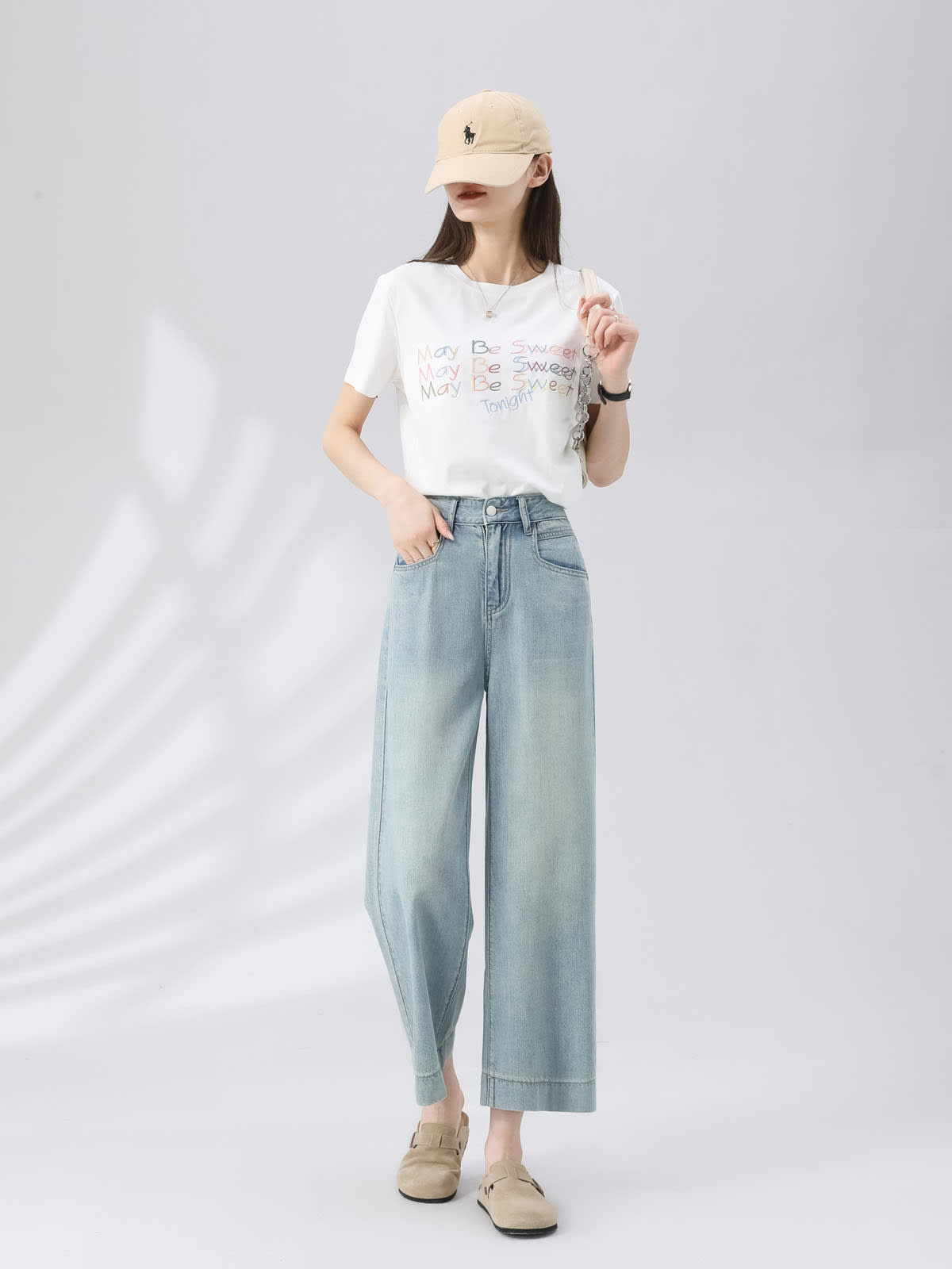 YEEYEEWang Wide-Leg Jeans in Light Blue, Asian-fit cut, full-body front standing pose with hand in pocket, beige cap, white graphic tee and chain shoulder bag.