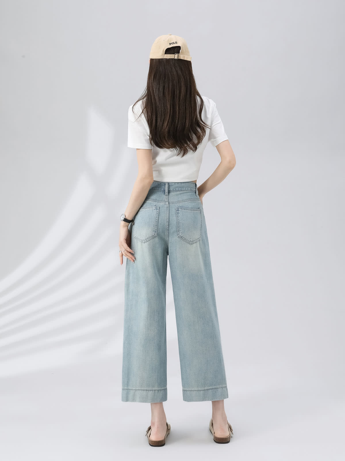YEEYEEWang Wide-Leg Jeans in Light Blue, Asian-fit cut, full-body back view standing with hand resting on waistband, showing back patch pockets and beige cap.