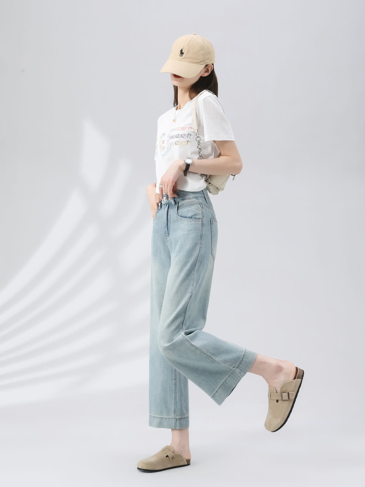 YEEYEEWang Wide-Leg Jeans in Light Blue, Asian-fit cut, full-body side view with leg-kick pose, beige cap and chain shoulder bag, fluid wide-leg drape.