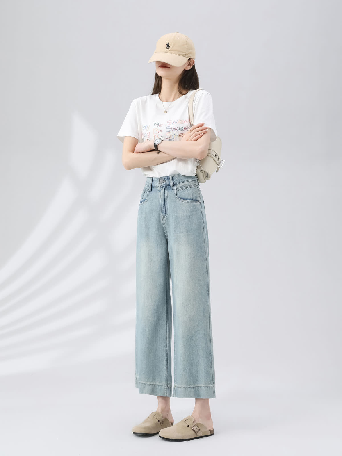 YEEYEEWang Wide-Leg Jeans in Light Blue, Asian-fit cut, full-body front view standing with arms crossed, beige cap and shoulder bag, wide stitched hems.