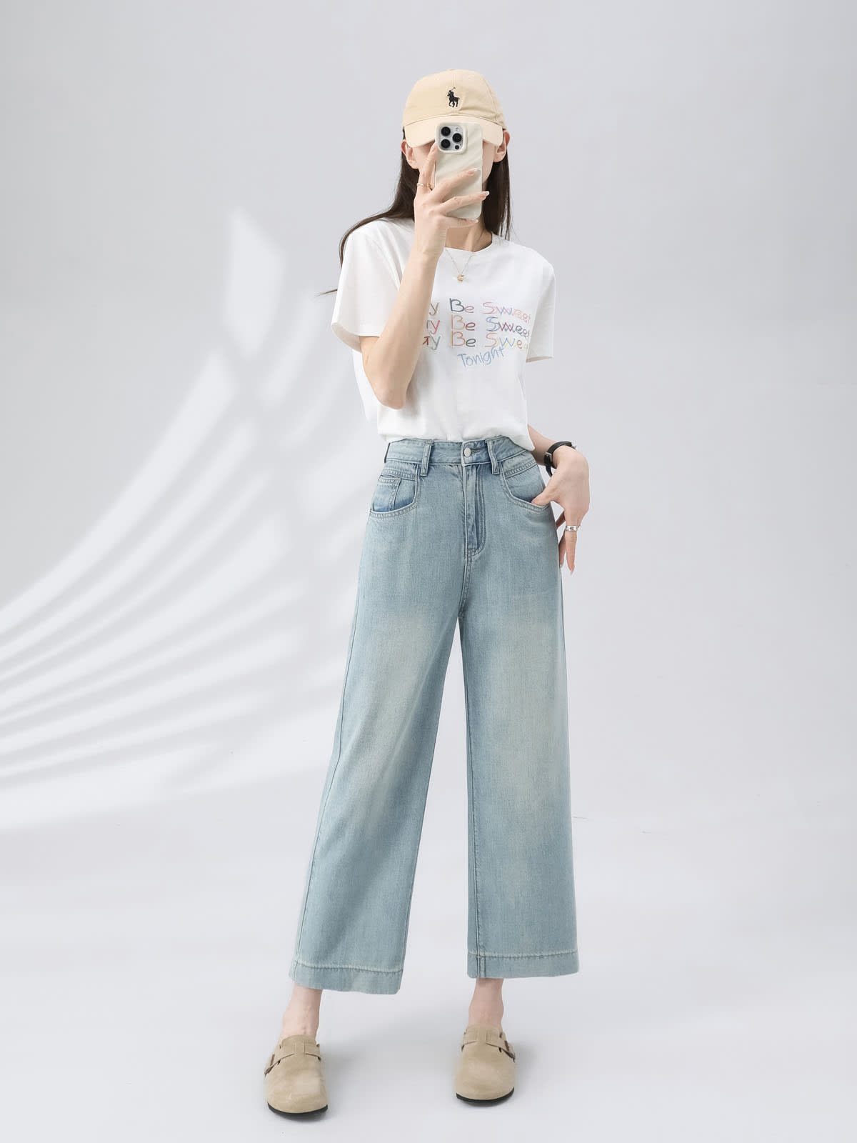 YEEYEEWang Wide-Leg Jeans in Light Blue, Asian-fit cut, full-body front pose holding phone at face, other hand in pocket, beige cap.
