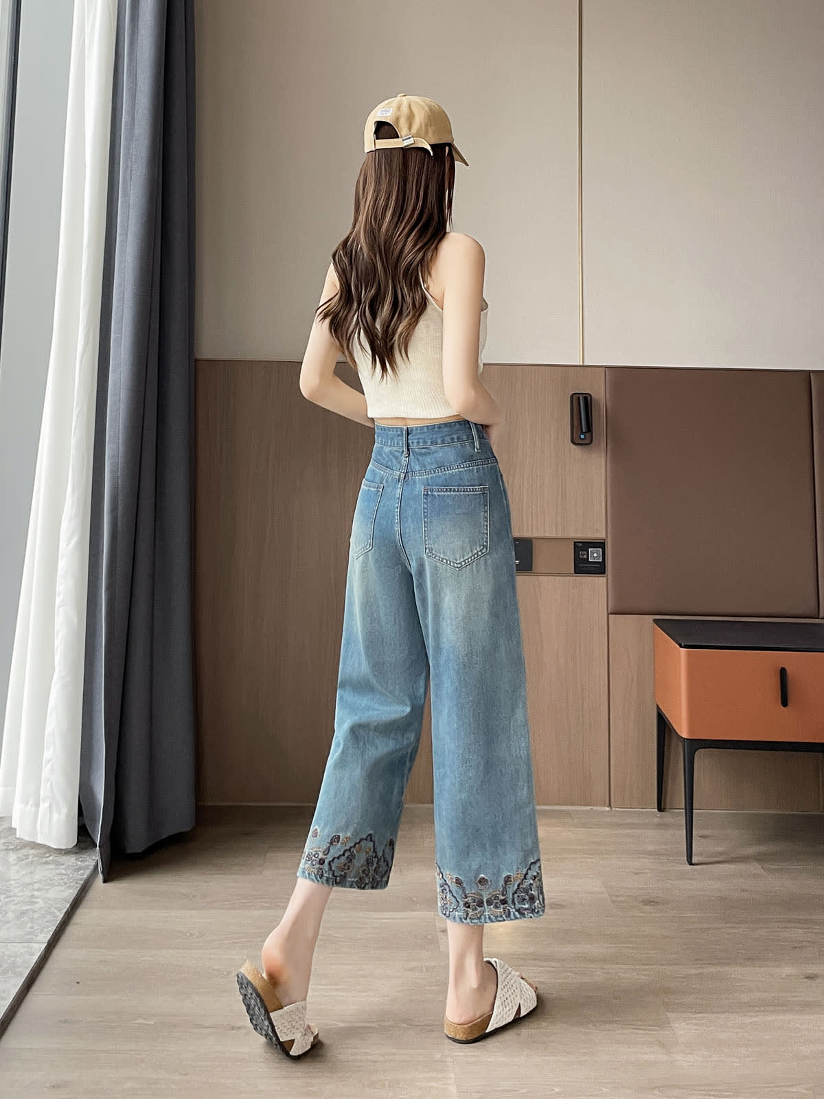 YEEYEEWang Straight Jeans in Vintage Blue, Asian-fit cut, full-body back walking view showing back patch pockets, cap on head, floral-embroidered hems.
