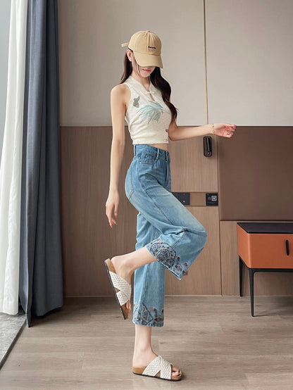 YEEYEEWang Straight Jeans in Vintage Blue, Asian-fit cut, full-body side leg-kick pose showing fluid drape, cap and embroidered knit top, floral-embroidered hems.